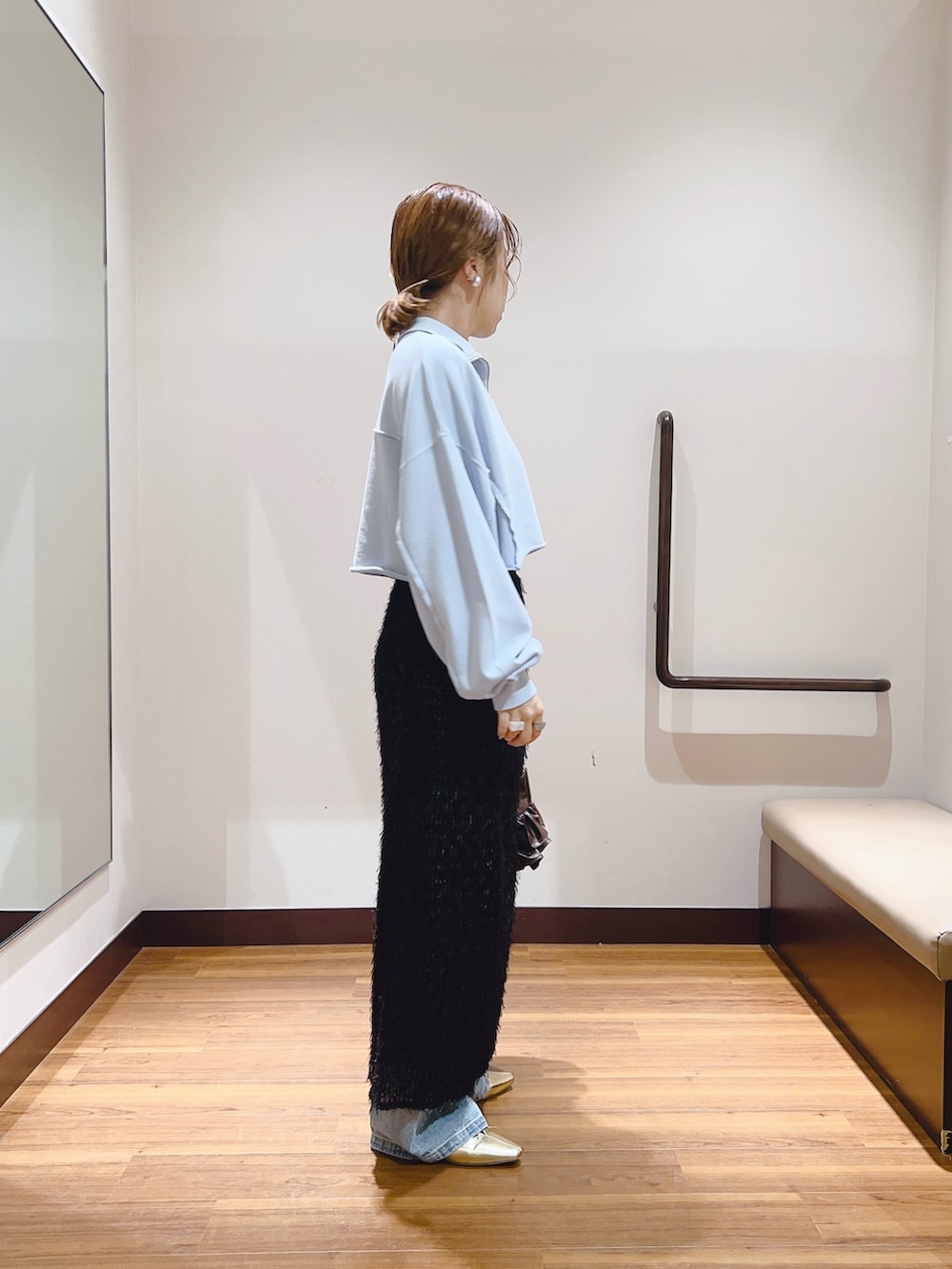 ブルー系のデニムパンツ、ブルー系のスウェット、ブラック系のスカートを着用したレディースの秋コーディネートの3枚目の写真