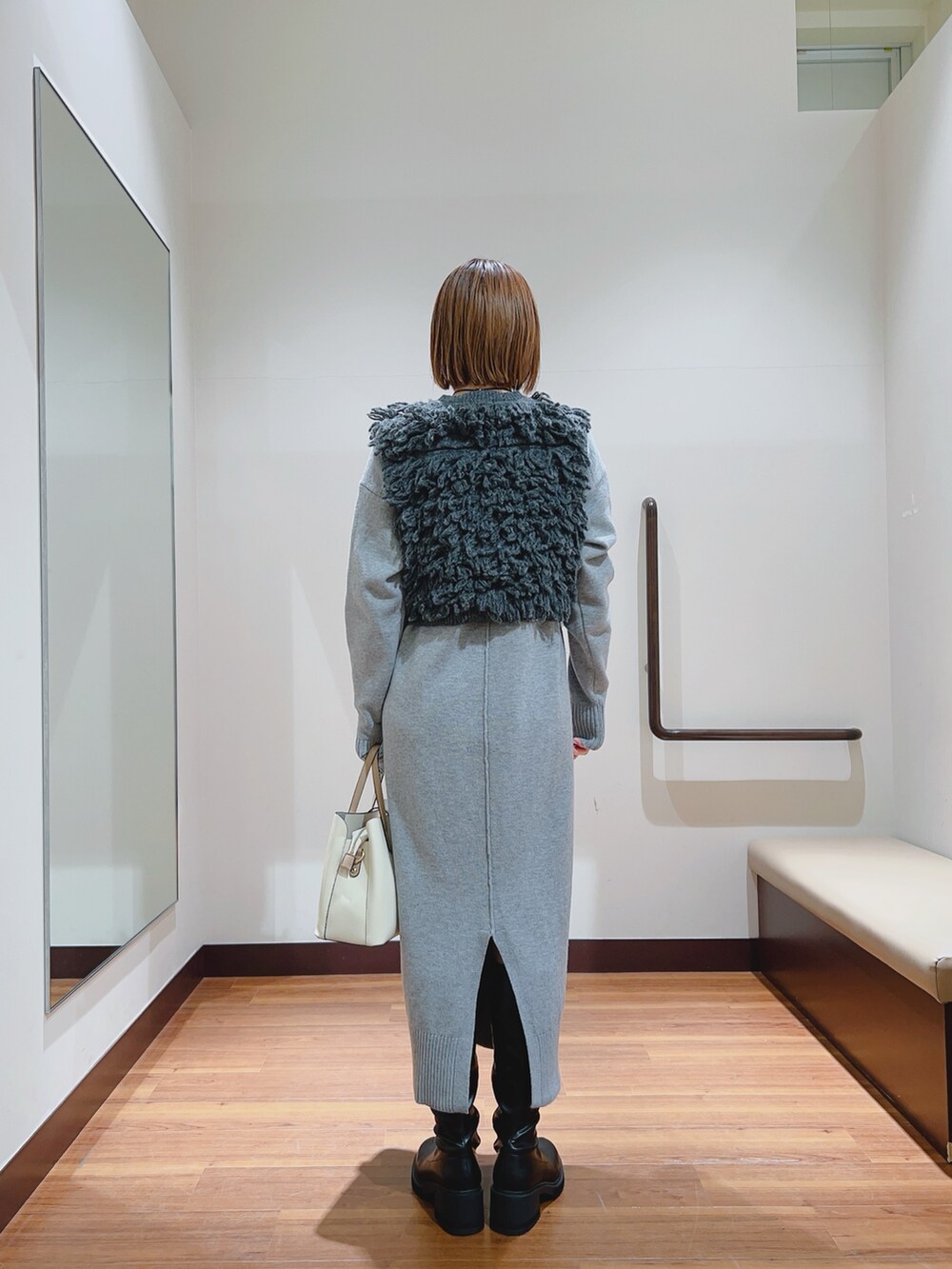 グレー系のワンピース、ホワイト系のトートバッグを着用したレディースの冬コーディネートの5枚目の写真