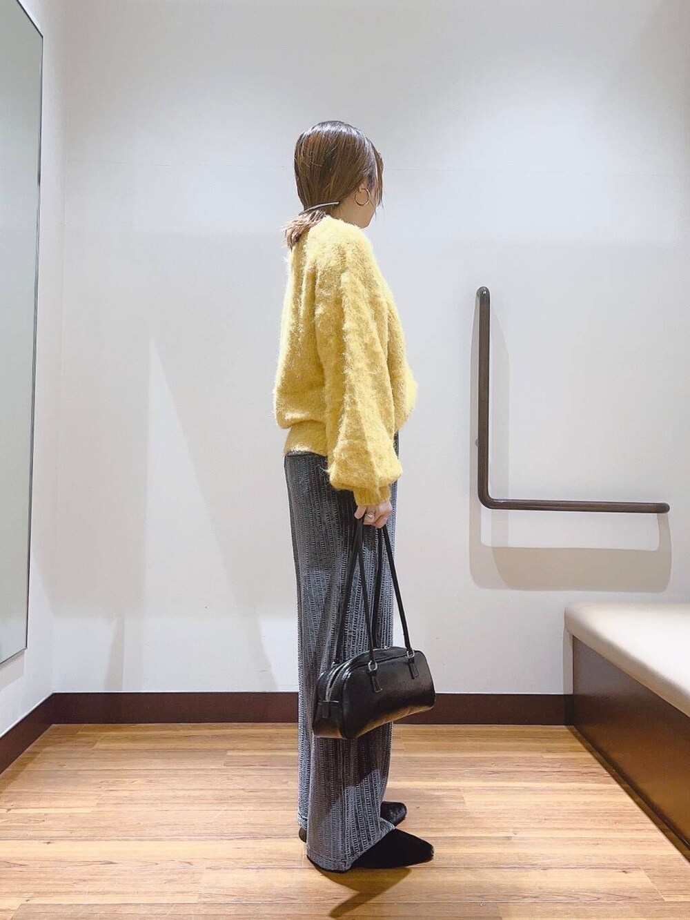 イエロー系のニット/セーター、ブラック系のその他シューズ、グレー系のその他パンツを着用したレディースの秋コーディネートの4枚目の写真