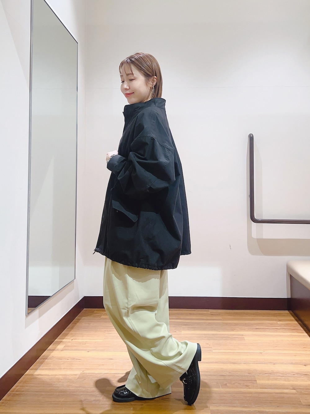 ブルー系のシャツ/ブラウス、ブラック系のモッズコート、ベージュ系のその他パンツを着用したレディースの春コーディネートの2枚目の写真