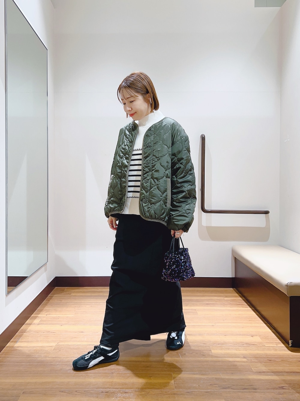 ホワイト系のダウンジャケット/コート、ブラック系のスカートを着用したレディースの冬コーディネートの5枚目の写真