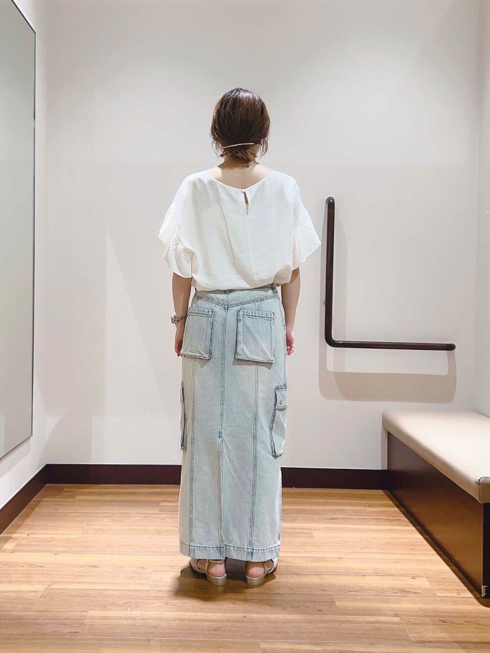 ゴールド系のサンダル、ベージュ系のトートバッグ、ブルー系のスカートを着用したレディースの夏コーディネートの3枚目の写真