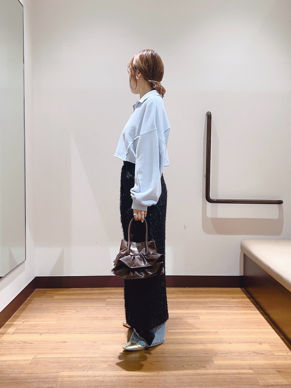 ブルー系のデニムパンツ、ブルー系のスウェット、ブラック系のスカートを着用したレディースの秋コーディネートの2枚目の写真