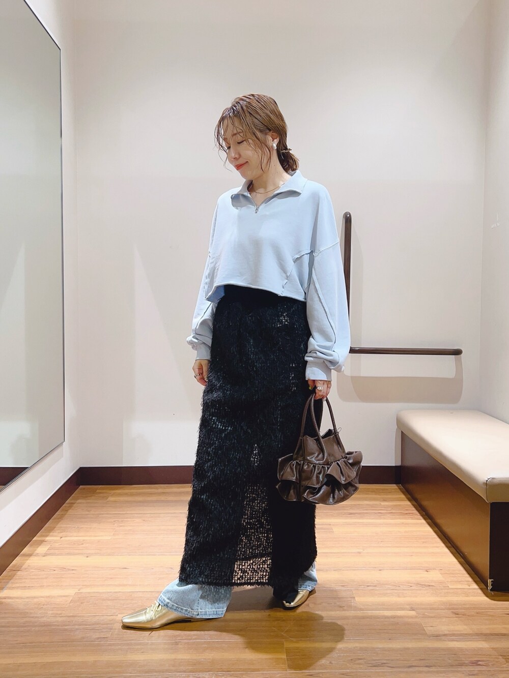 ブルー系のデニムパンツ、ブルー系のスウェット、ブラック系のスカートを着用したレディースの秋コーディネートの5枚目の写真