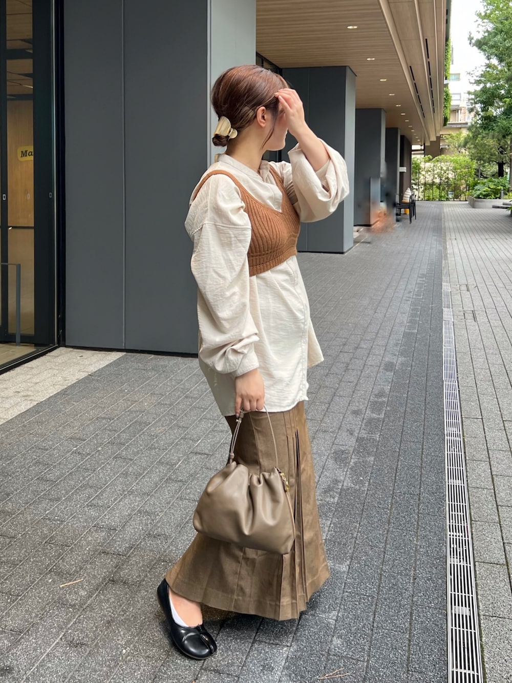 ベージュ系のシャツ/ブラウス、ブラウン系のトップス、ブラウン系のショルダーバッグを着用したレディースの秋コーディネートの2枚目の写真