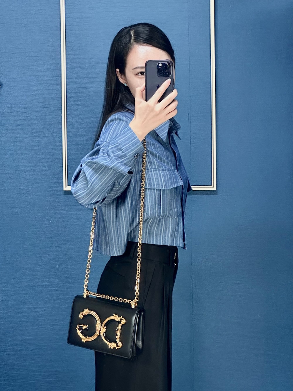 ゴールド系のショルダーバッグ、ブラック系のローファーを着用したレディースの秋コーディネートの2枚目の写真