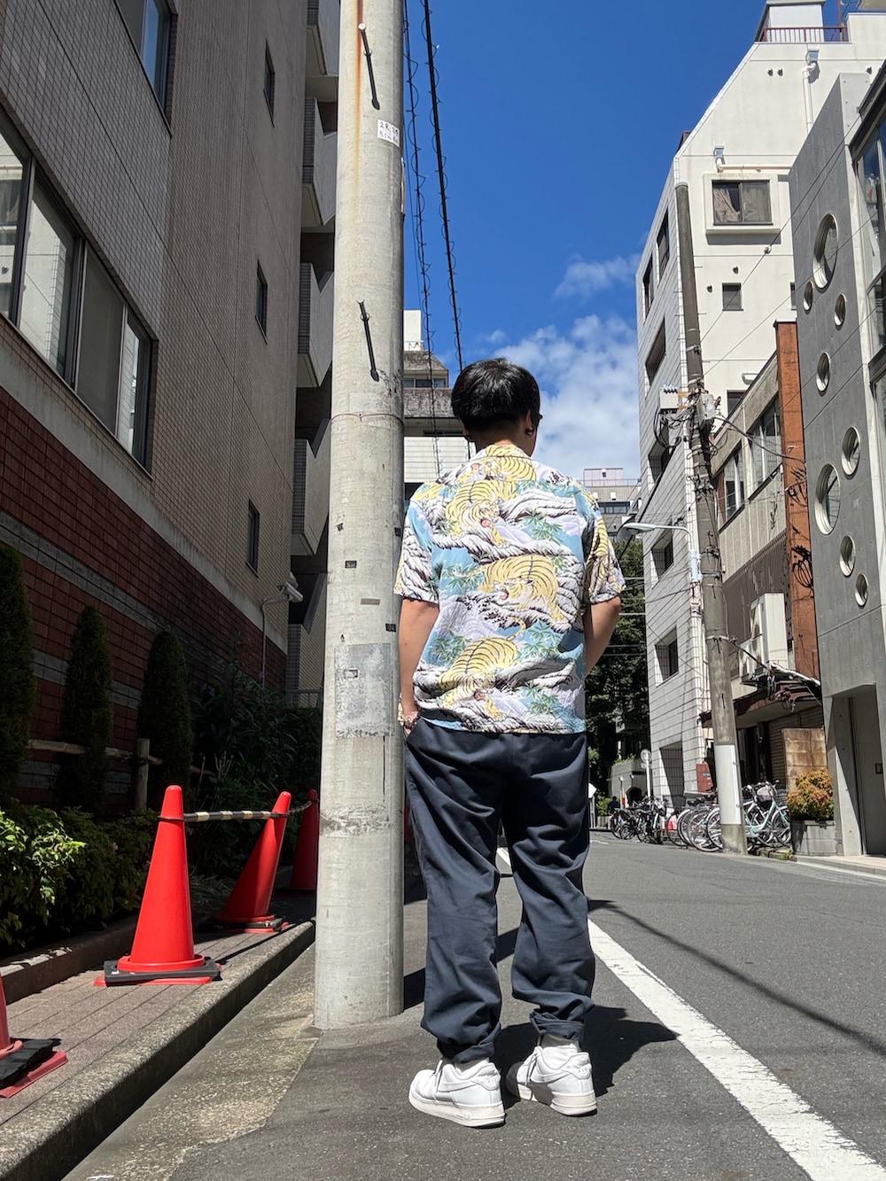 ホワイト系のスニーカー、ブルー系のチノパンツ、ブラック系のTシャツ/カットソーを着用したメンズの夏コーディネートの2枚目の写真