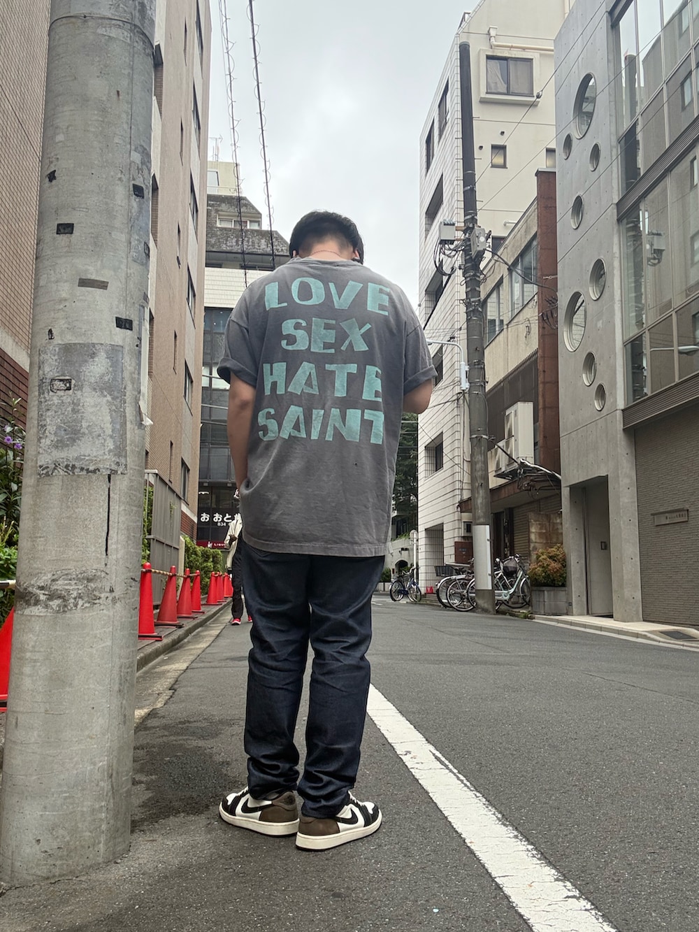 ブラック系のスニーカー、ブルー系のデニムパンツ、ブラック系のTシャツ/カットソーを着用したメンズの夏コーディネートの2枚目の写真