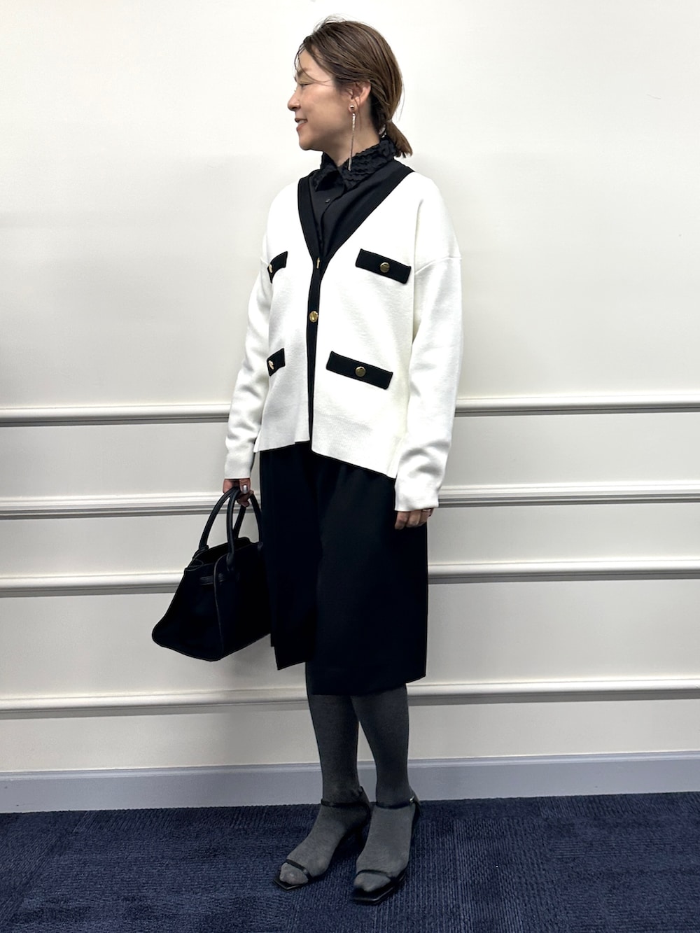 ホワイト系のカーディガン/ボレロ、ブラック系のシャツ/ブラウス、ブラック系のトートバッグを着用したレディースの冬コーディネートの7枚目の写真