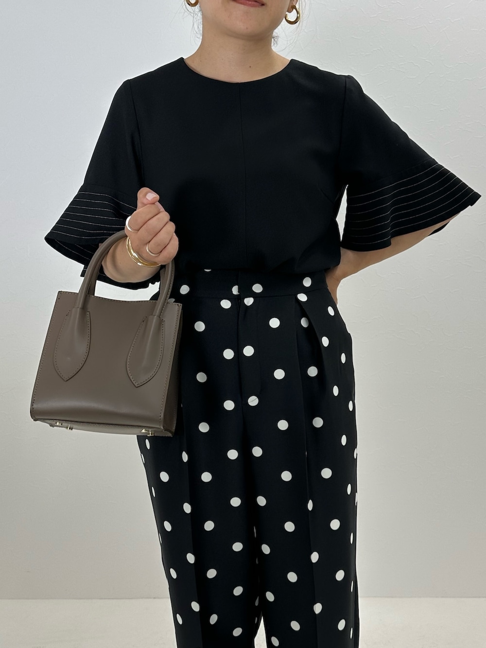 ブラック系のシャツ/ブラウス、ブラック系のその他パンツ、ベージュ系のトートバッグを着用したレディースの夏コーディネートの9枚目の写真