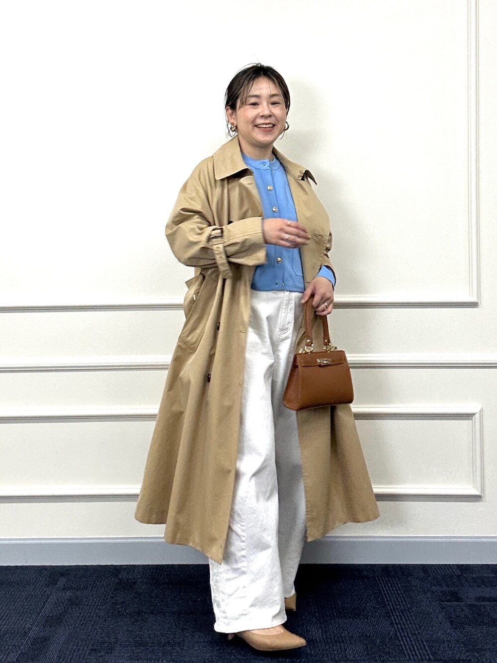 ベージュ系のトレンチコート、ブルー系のカーディガン/ボレロ、イエロー系のショルダーバッグを着用したレディースの春コーディネートの4枚目の写真