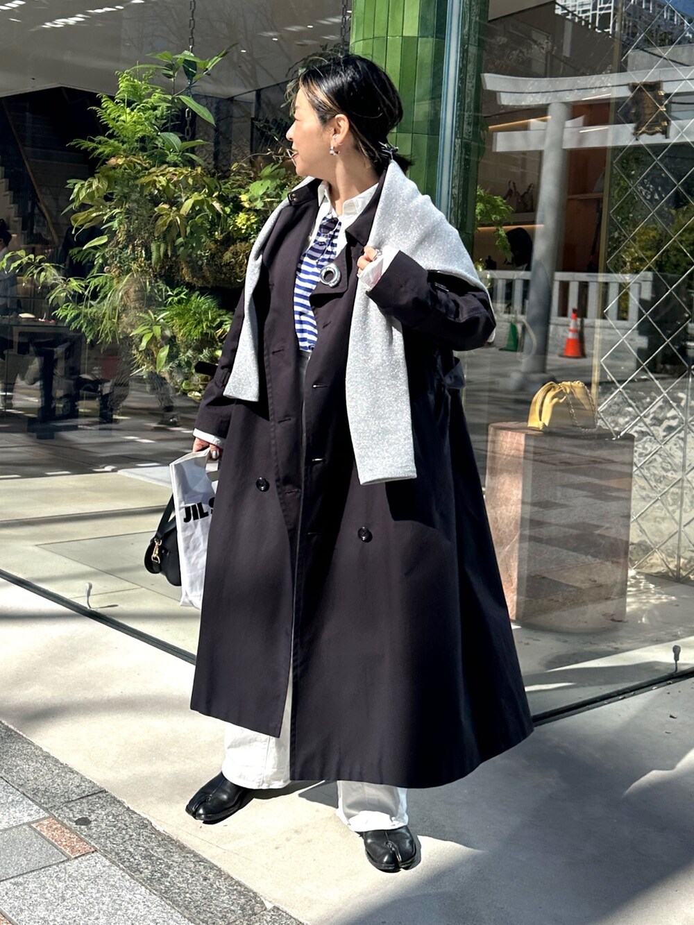 ブルー系のトレンチコート、ブルー系のTシャツ/カットソー、グレー系のTシャツ/カットソーを着用したレディースの春コーディネートの6枚目の写真