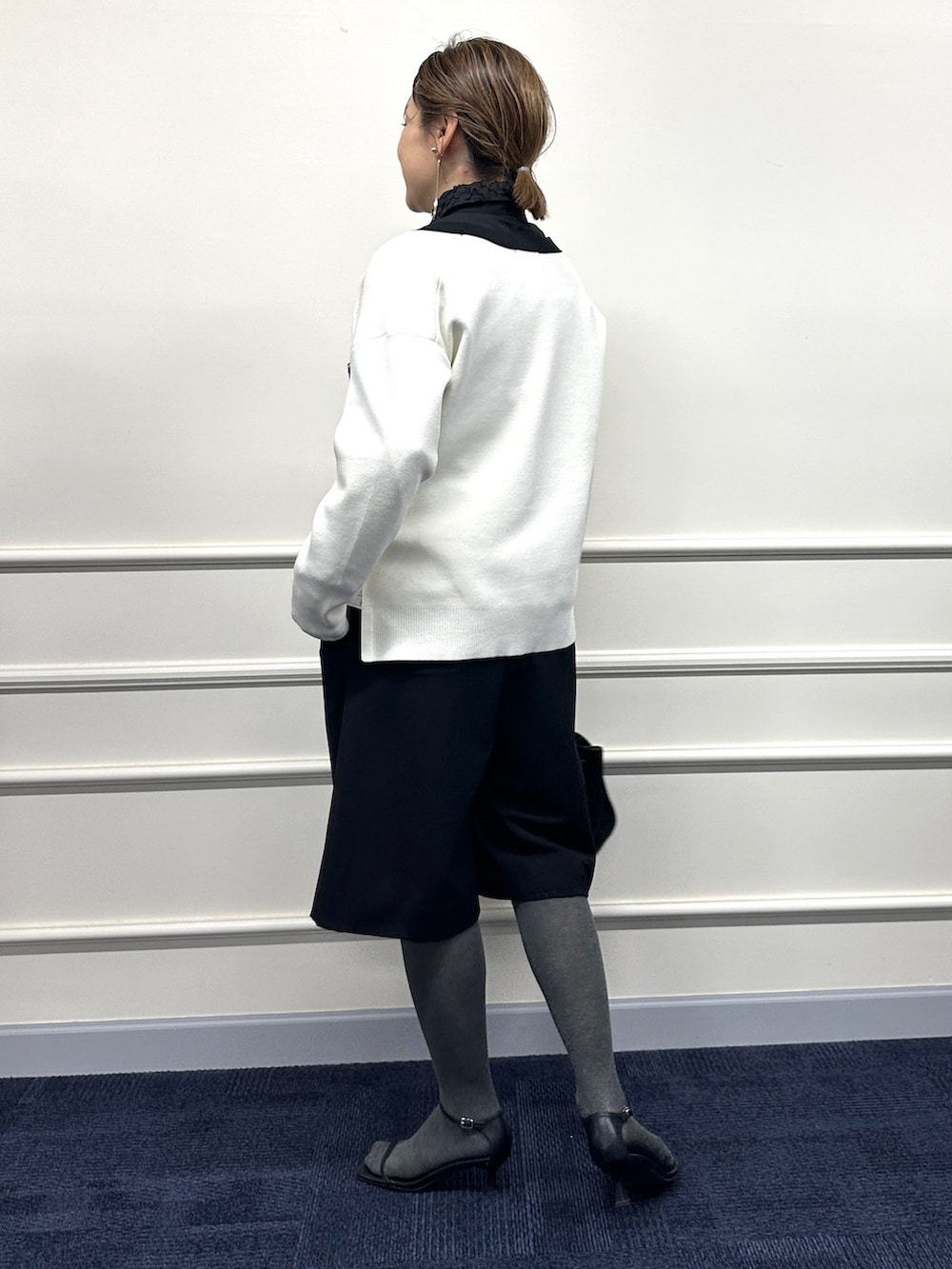 ホワイト系のカーディガン/ボレロ、ブラック系のシャツ/ブラウス、ブラック系のトートバッグを着用したレディースの冬コーディネートの6枚目の写真