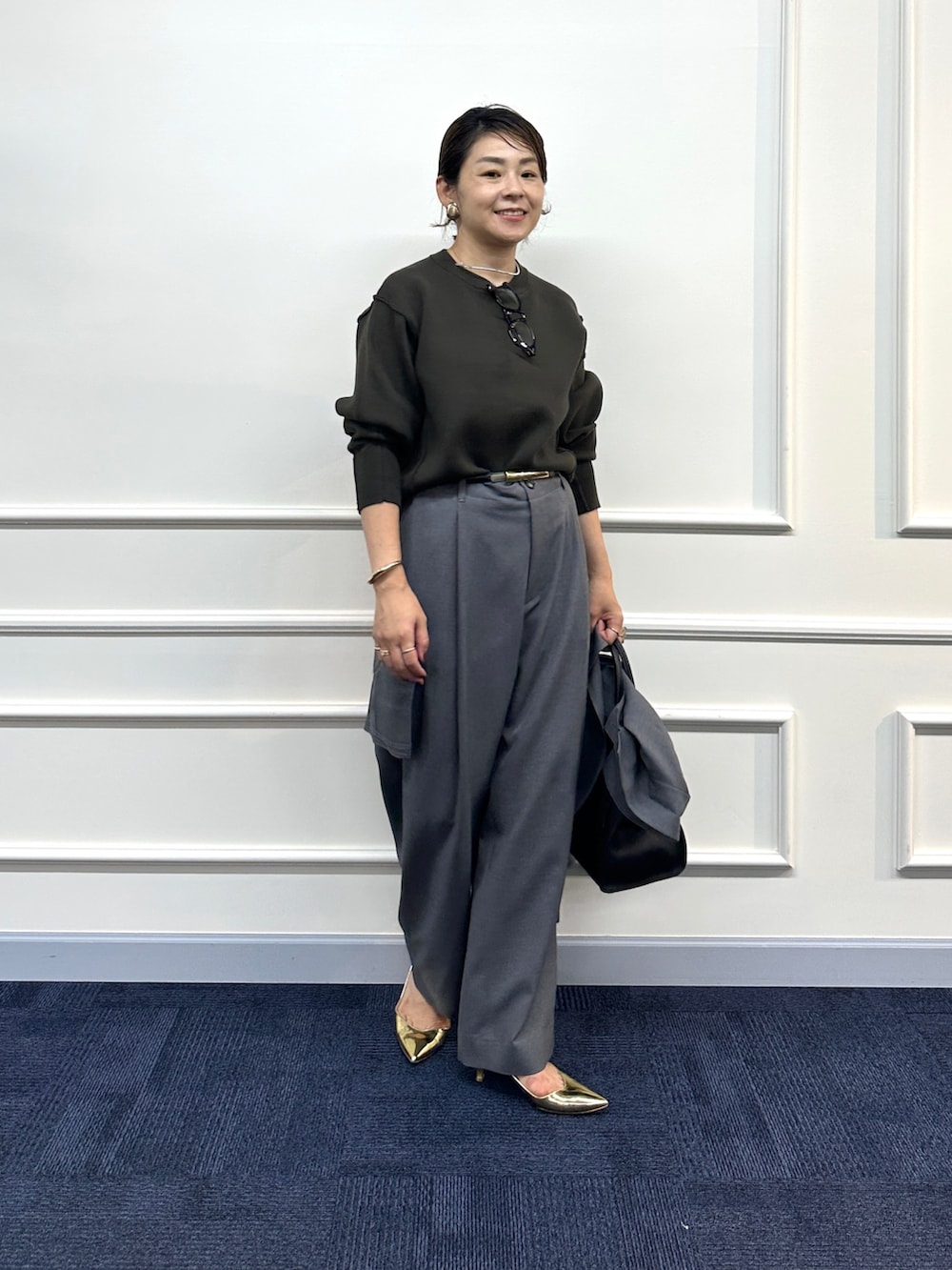 ブラウン系のニット/セーター、グレー系のその他パンツ、グレー系のシャツ/ブラウスを着用したレディースの秋コーディネートの3枚目の写真