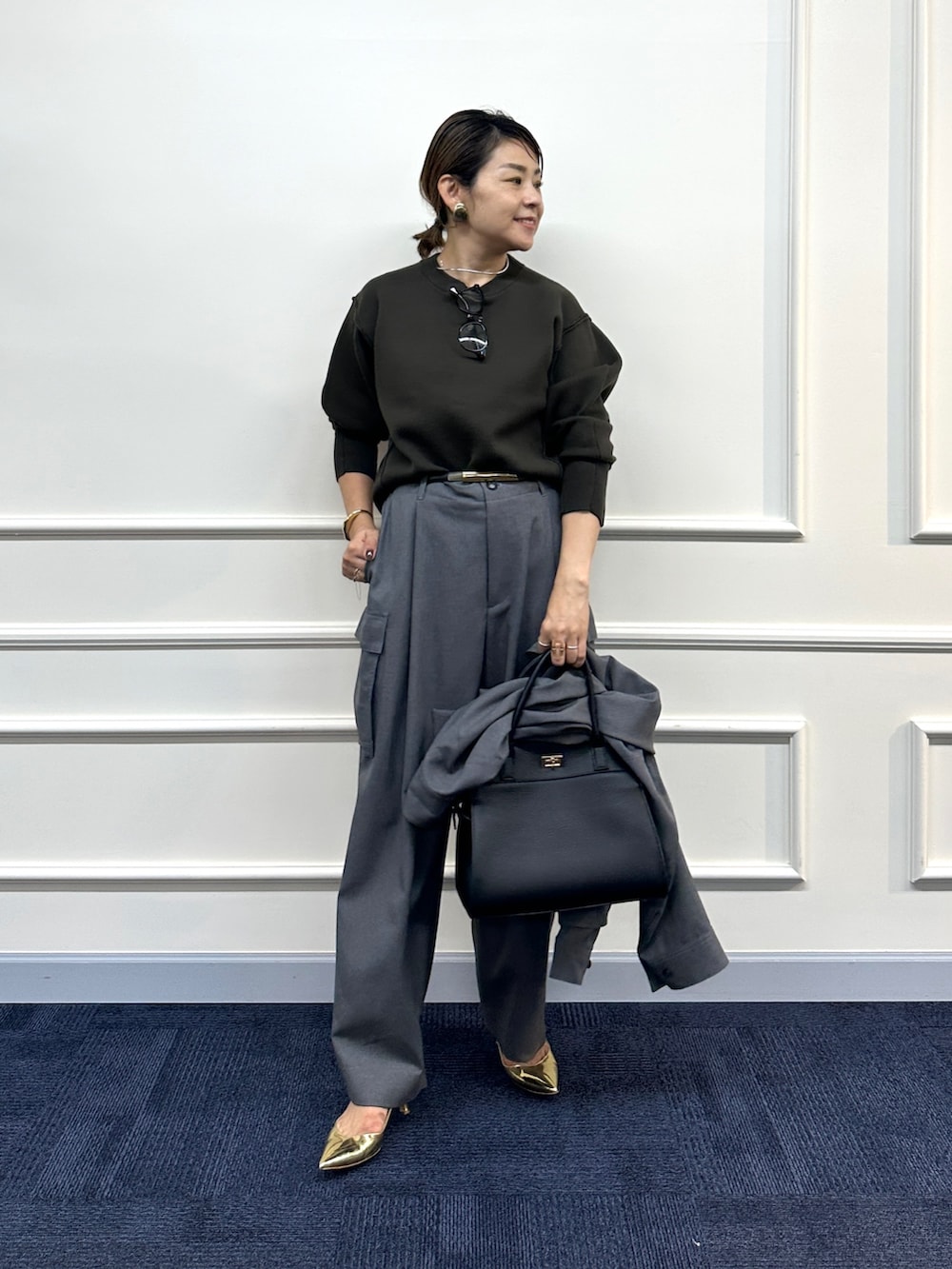 ブラウン系のニット/セーター、グレー系のその他パンツ、グレー系のシャツ/ブラウスを着用したレディースの秋コーディネートの2枚目の写真