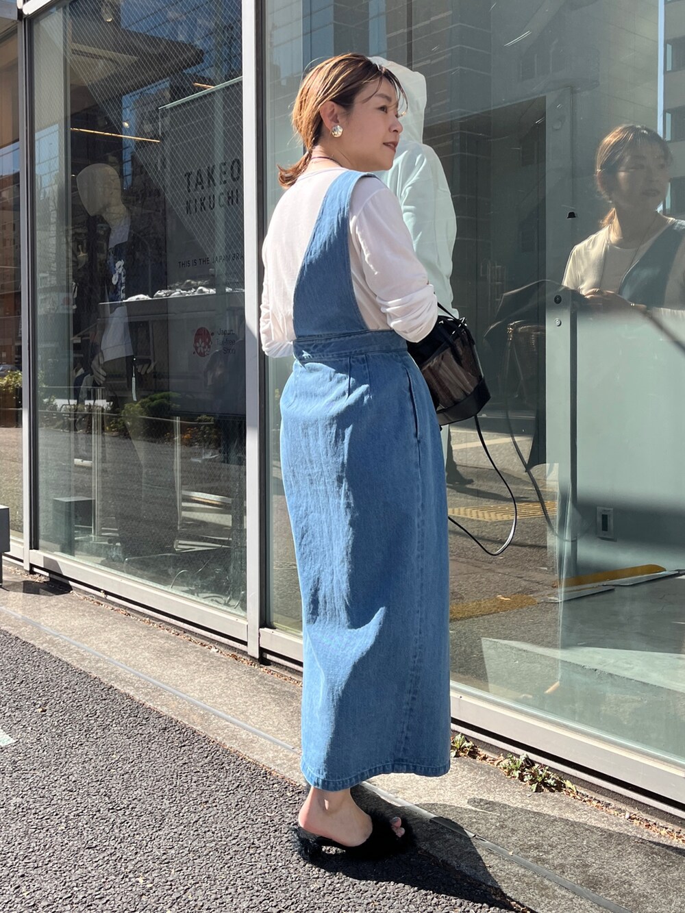 ブラック系のベスト、ホワイト系のTシャツ/カットソー、ブルー系のワンピースを着用したレディースの冬コーディネートの7枚目の写真