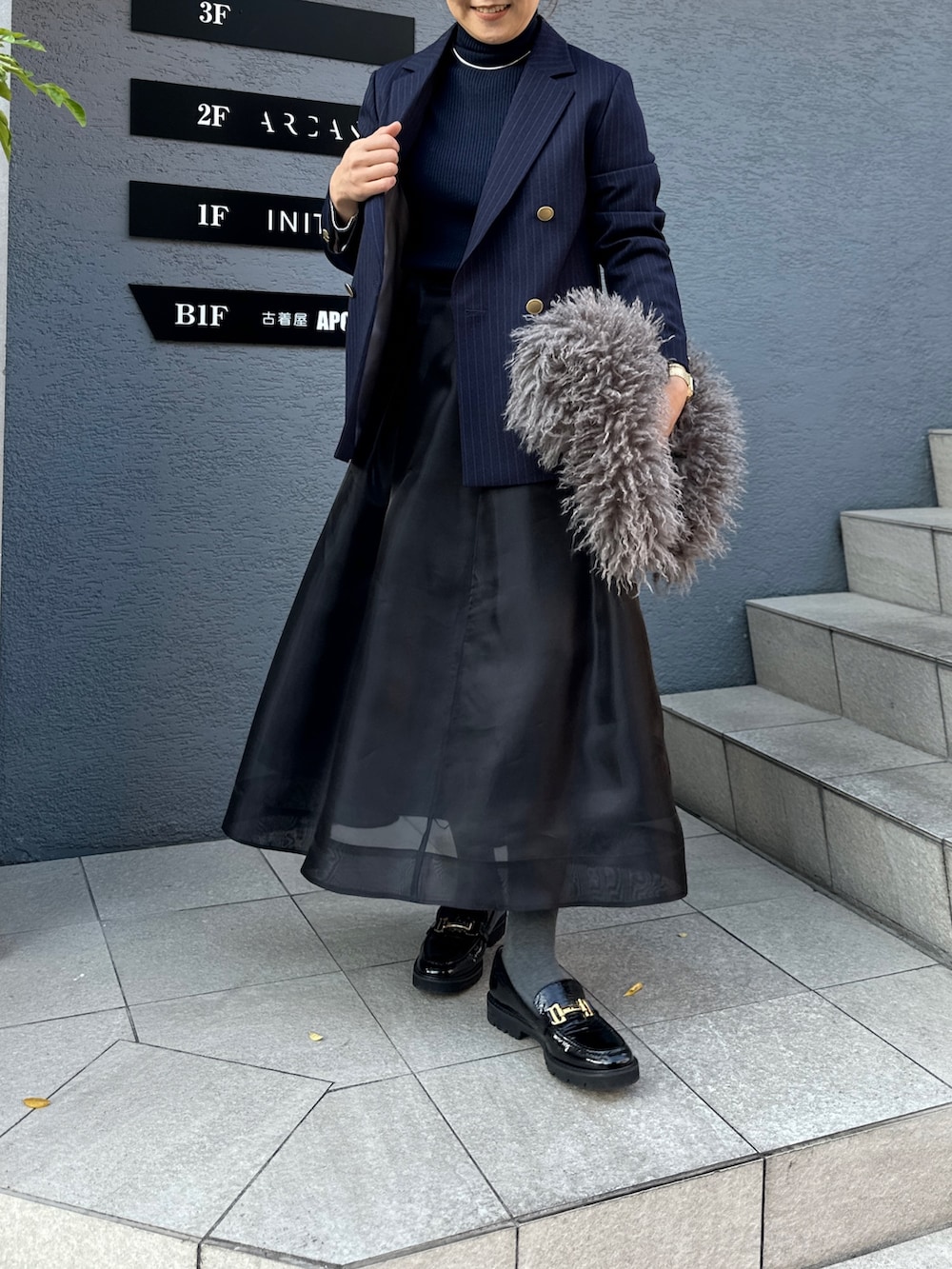 ブラック系のスカート、ブルー系のその他トップス、ブルー系のテーラードジャケットを着用したレディースの冬コーディネートの9枚目の写真