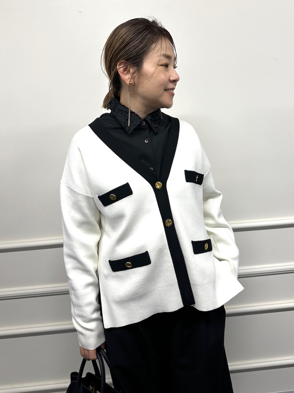 ホワイト系のカーディガン/ボレロ、ブラック系のシャツ/ブラウス、ブラック系のトートバッグを着用したレディースの冬コーディネートの8枚目の写真