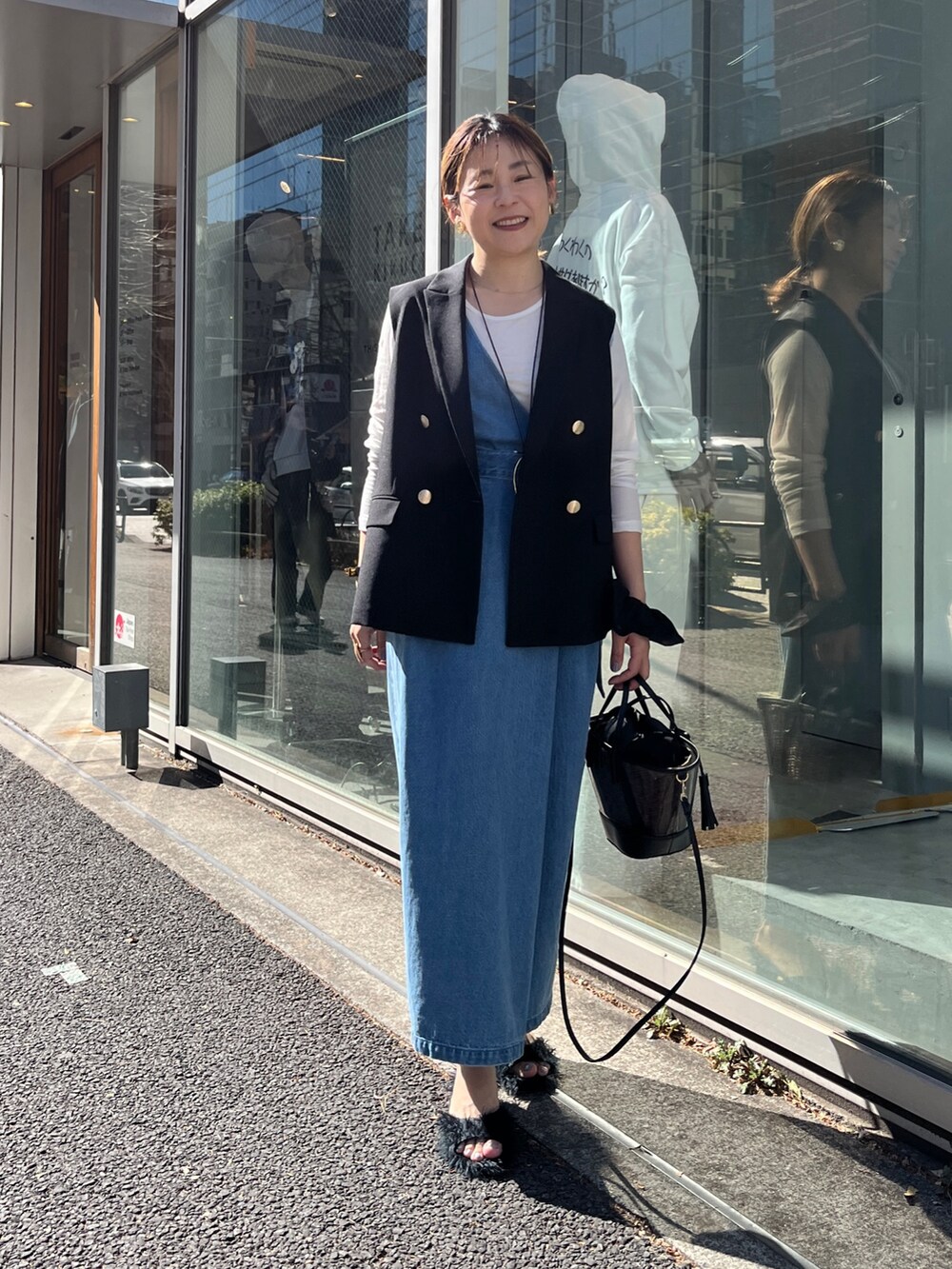 ブラック系のベスト、ホワイト系のTシャツ/カットソー、ブルー系のワンピースを着用したレディースの冬コーディネートの5枚目の写真