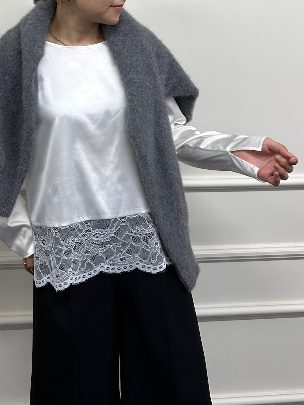 グレー系のニット/セーター、ホワイト系のシャツ/ブラウス、ブラック系のその他パンツを着用したレディースの秋コーディネートの4枚目の写真