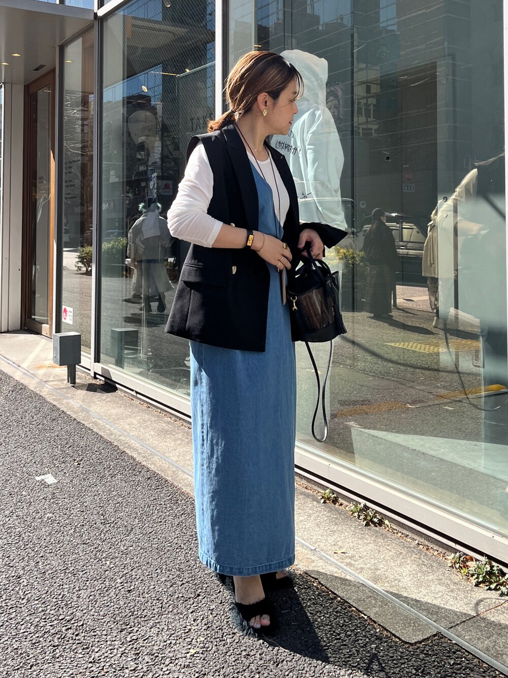 ブラック系のベスト、ホワイト系のTシャツ/カットソー、ブルー系のワンピースを着用したレディースの冬コーディネートの3枚目の写真