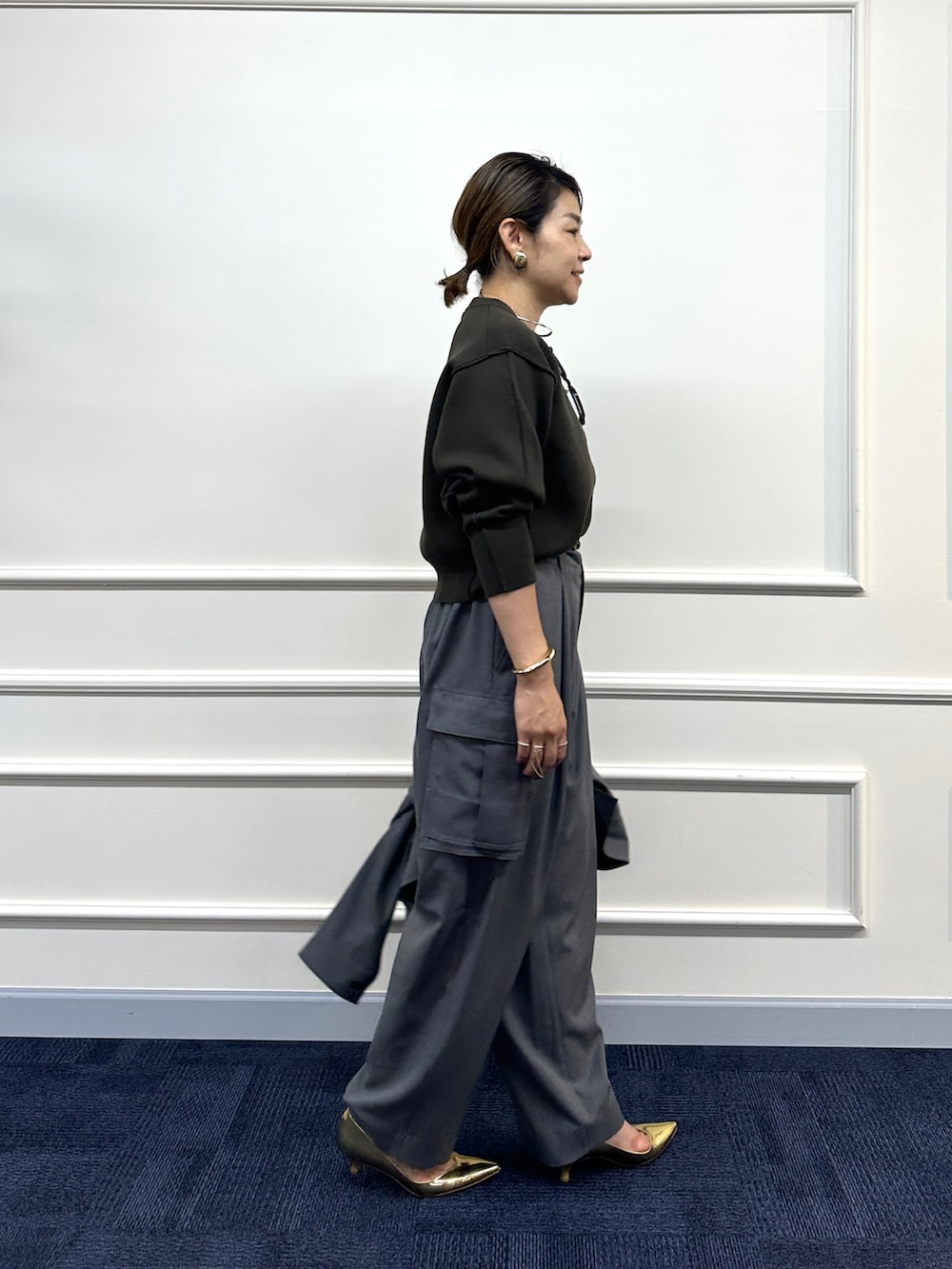 ブラウン系のニット/セーター、グレー系のその他パンツ、グレー系のシャツ/ブラウスを着用したレディースの秋コーディネートの5枚目の写真