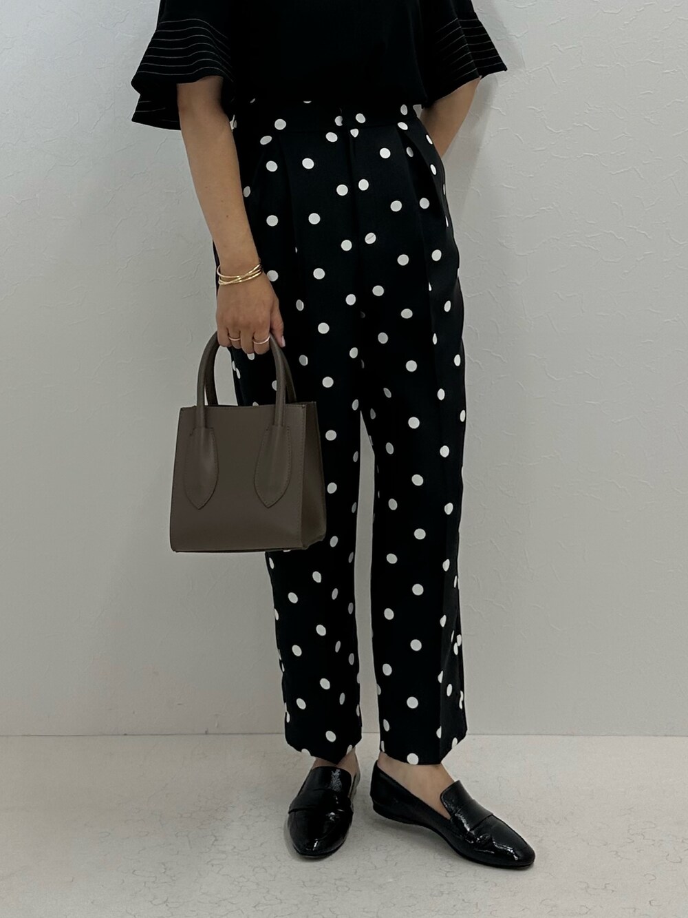 ブラック系のシャツ/ブラウス、ブラック系のその他パンツ、ベージュ系のトートバッグを着用したレディースの夏コーディネートの10枚目の写真