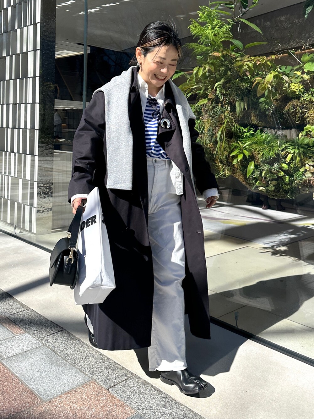 ブルー系のトレンチコート、ブルー系のTシャツ/カットソー、グレー系のTシャツ/カットソーを着用したレディースの春コーディネートの5枚目の写真