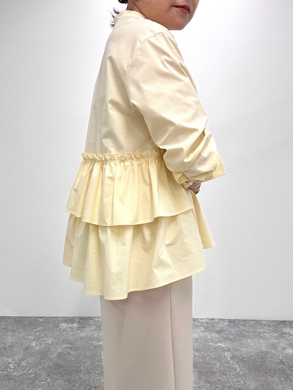 イエロー系のシャツ/ブラウス、ベージュ系のスカート、イエロー系のショルダーバッグを着用したレディースの春コーディネートの5枚目の写真