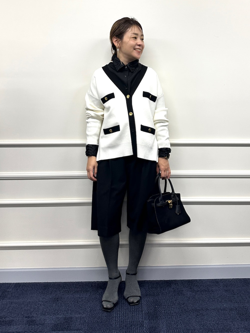ホワイト系のカーディガン/ボレロ、ブラック系のシャツ/ブラウス、ブラック系のトートバッグを着用したレディースの冬コーディネートの3枚目の写真