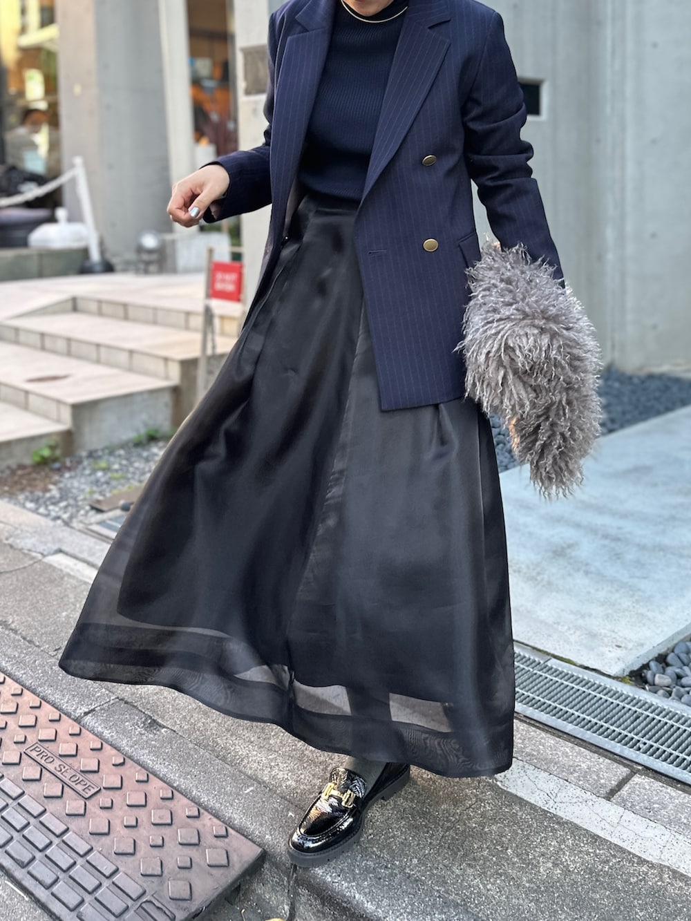 ブラック系のスカート、ブルー系のその他トップス、ブルー系のテーラードジャケットを着用したレディースの冬コーディネートの7枚目の写真