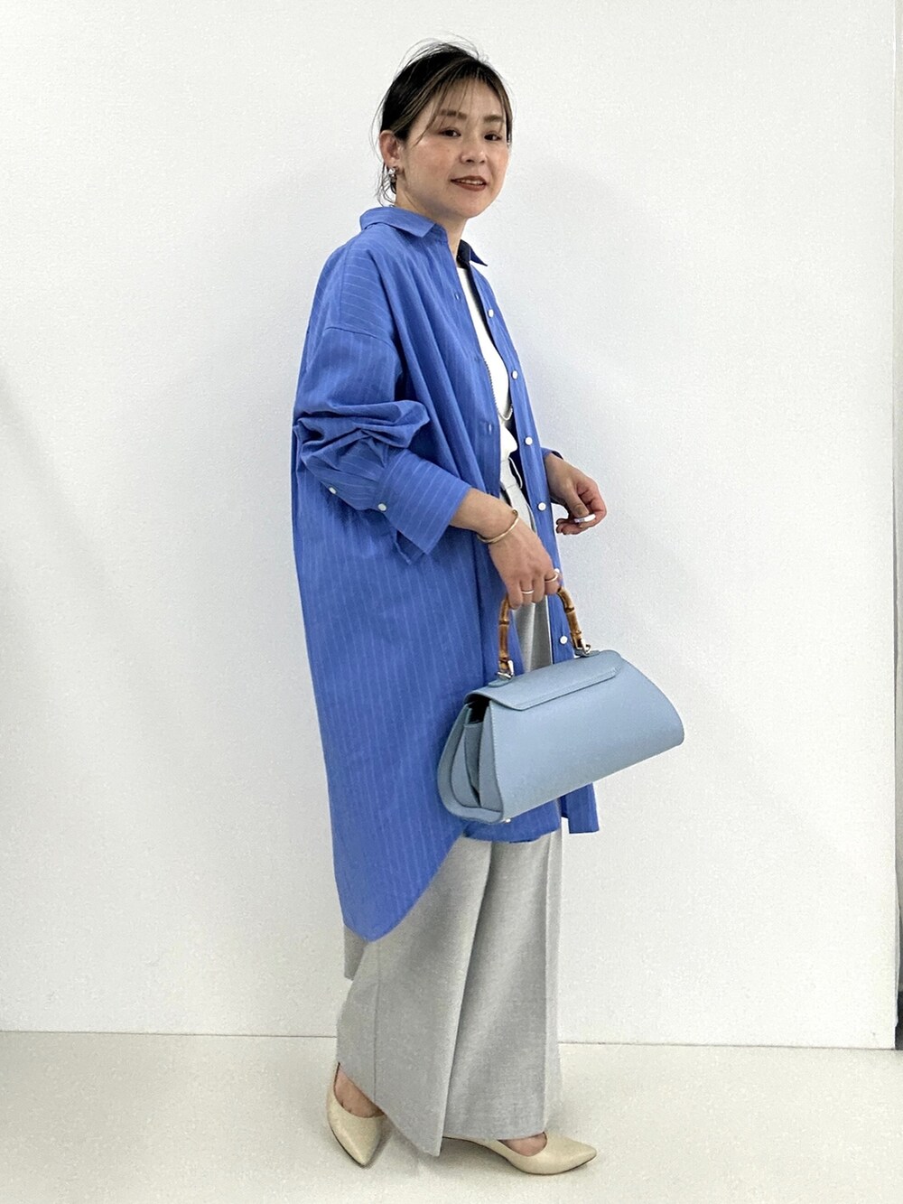 グレー系のその他パンツ、ホワイト系のタンクトップ、ブルー系のシャツワンピースを着用したレディースの春コーディネートの2枚目の写真