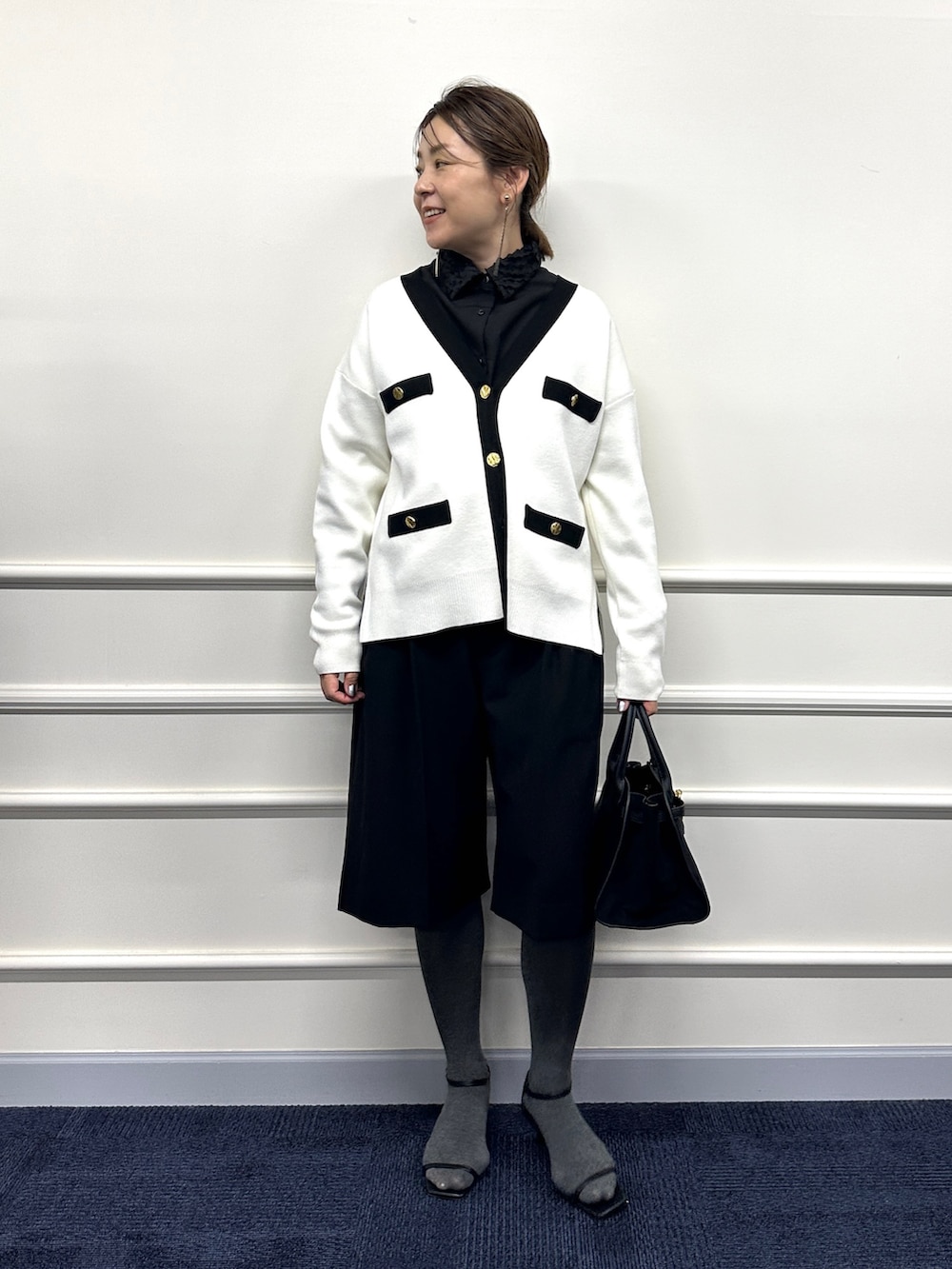ホワイト系のカーディガン/ボレロ、ブラック系のシャツ/ブラウス、ブラック系のトートバッグを着用したレディースの冬コーディネートの5枚目の写真