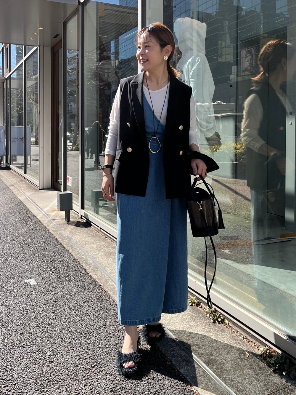 ブラック系のベスト、ホワイト系のTシャツ/カットソー、ブルー系のワンピースを着用したレディースの冬コーディネートの2枚目の写真
