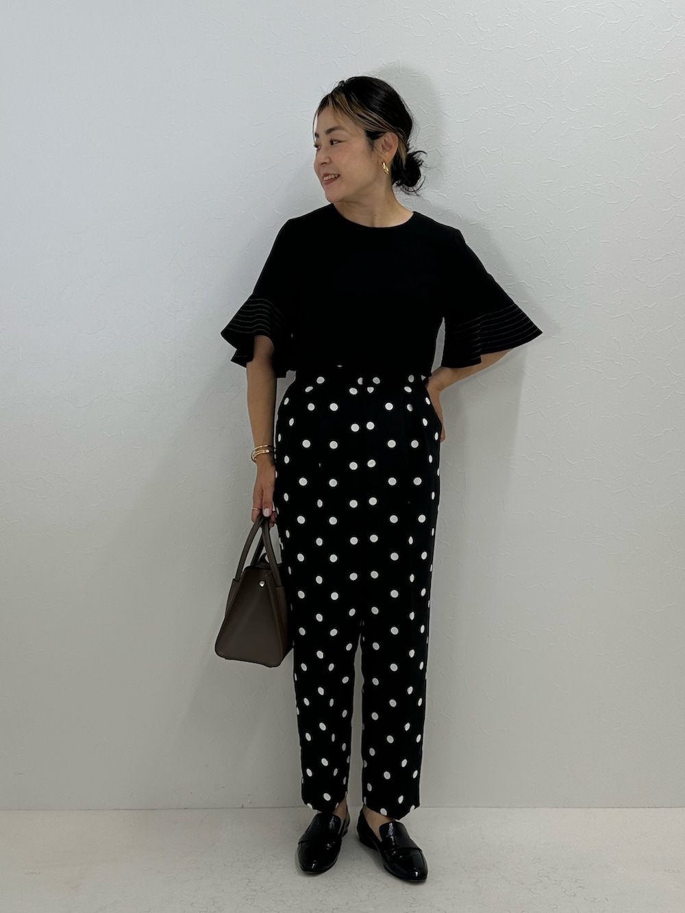 ブラック系のシャツ/ブラウス、ブラック系のその他パンツ、ベージュ系のトートバッグを着用したレディースの夏コーディネートの7枚目の写真