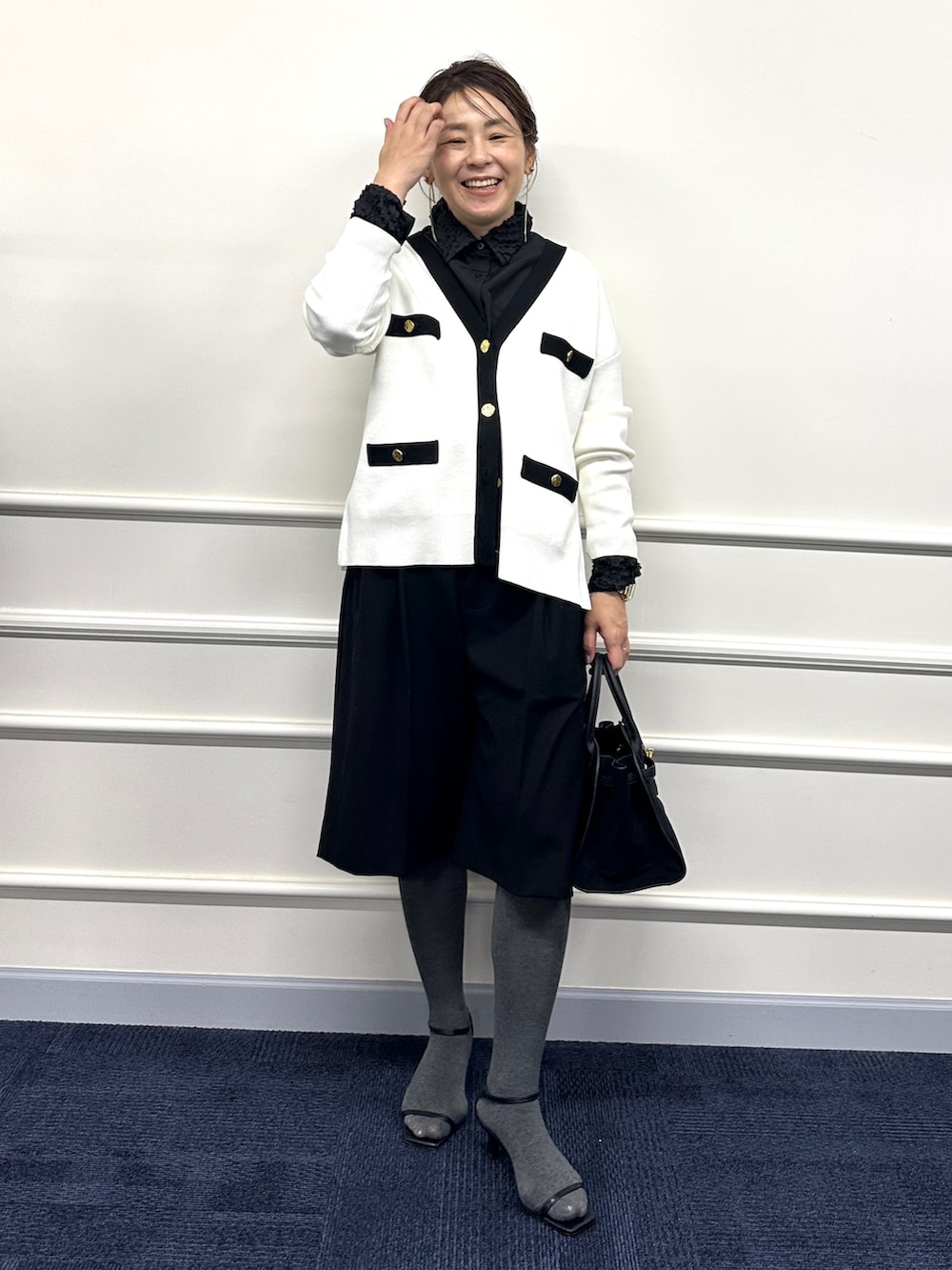 ホワイト系のカーディガン/ボレロ、ブラック系のシャツ/ブラウス、ブラック系のトートバッグを着用したレディースの冬コーディネートの2枚目の写真