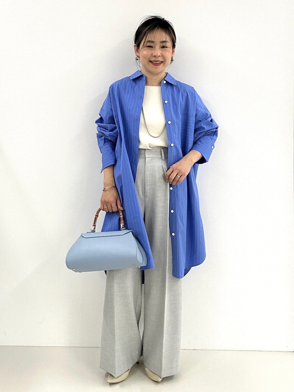 グレー系のその他パンツ、ホワイト系のタンクトップ、ブルー系のシャツワンピースを着用したレディースの春コーディネートの7枚目の写真