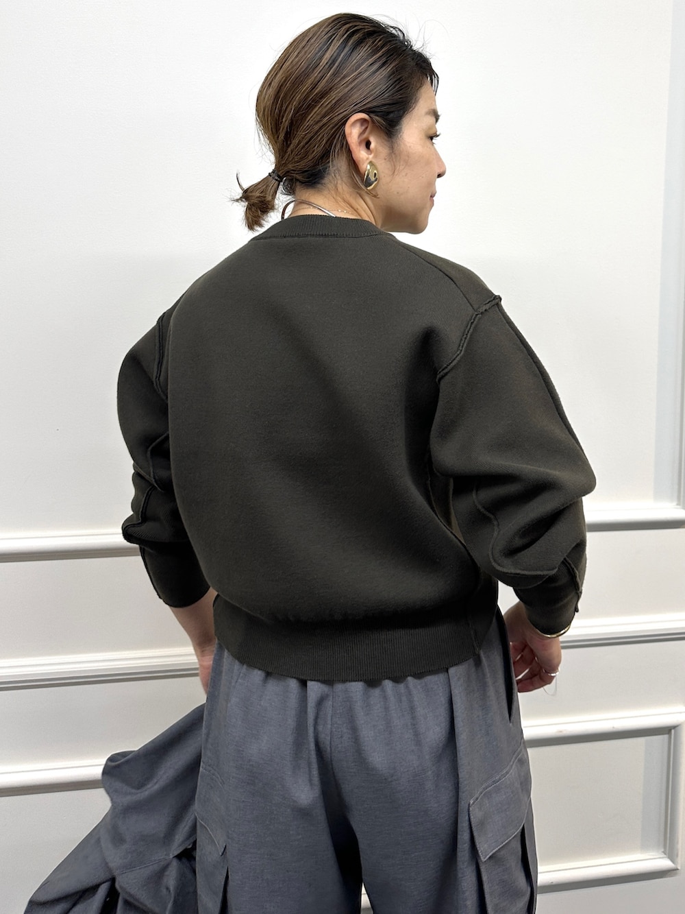 ブラウン系のニット/セーター、グレー系のその他パンツ、グレー系のシャツ/ブラウスを着用したレディースの秋コーディネートの9枚目の写真