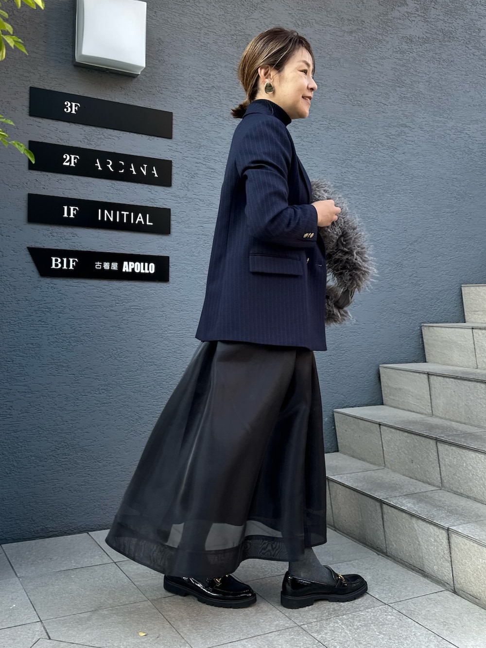 ブラック系のスカート、ブルー系のその他トップス、ブルー系のテーラードジャケットを着用したレディースの冬コーディネートの10枚目の写真