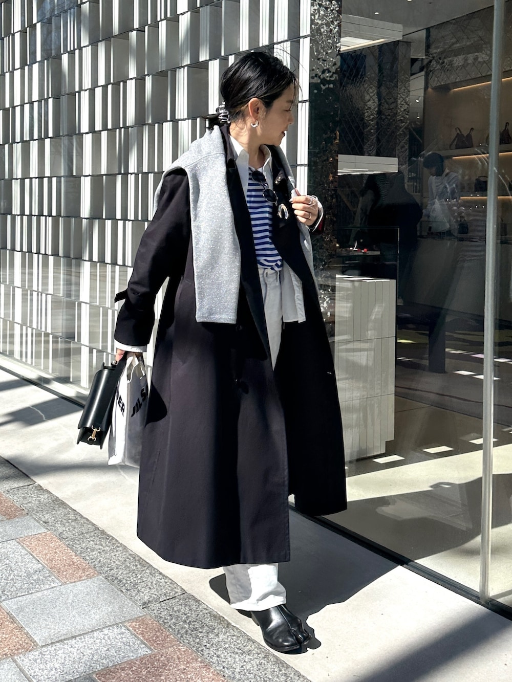 ブルー系のトレンチコート、ブルー系のTシャツ/カットソー、グレー系のTシャツ/カットソーを着用したレディースの春コーディネートの4枚目の写真