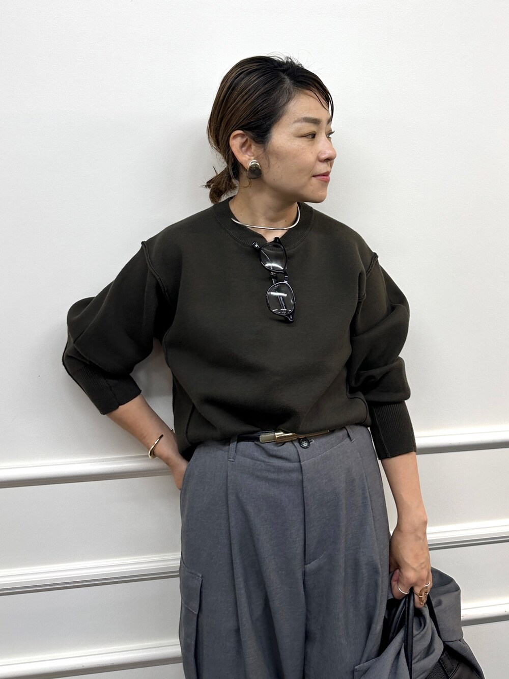 ブラウン系のニット/セーター、グレー系のその他パンツ、グレー系のシャツ/ブラウスを着用したレディースの秋コーディネートの7枚目の写真