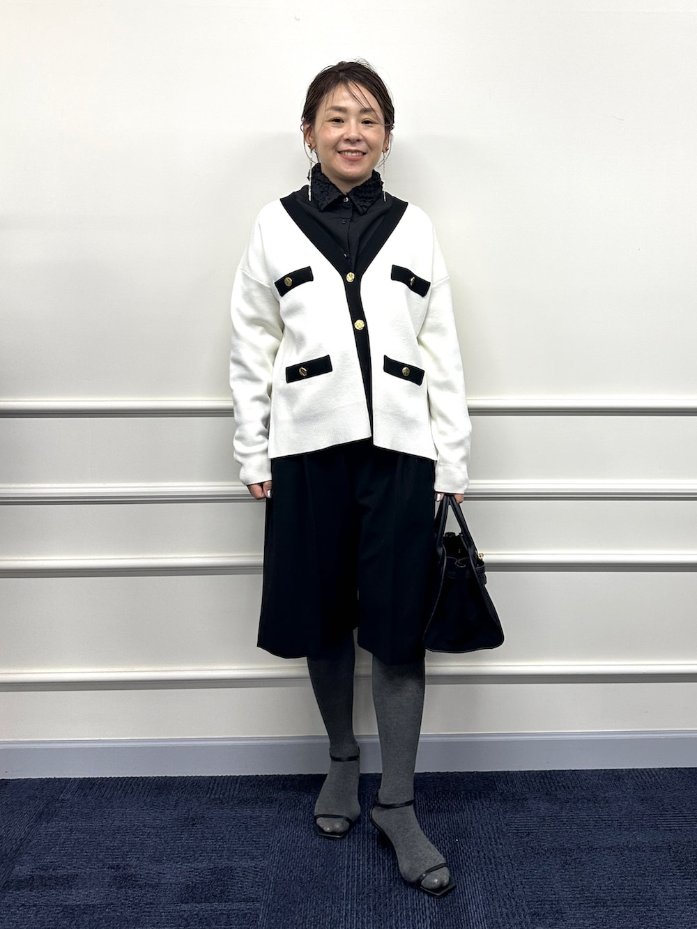ホワイト系のカーディガン/ボレロ、ブラック系のシャツ/ブラウス、ブラック系のトートバッグを着用したレディースの冬コーディネートの4枚目の写真