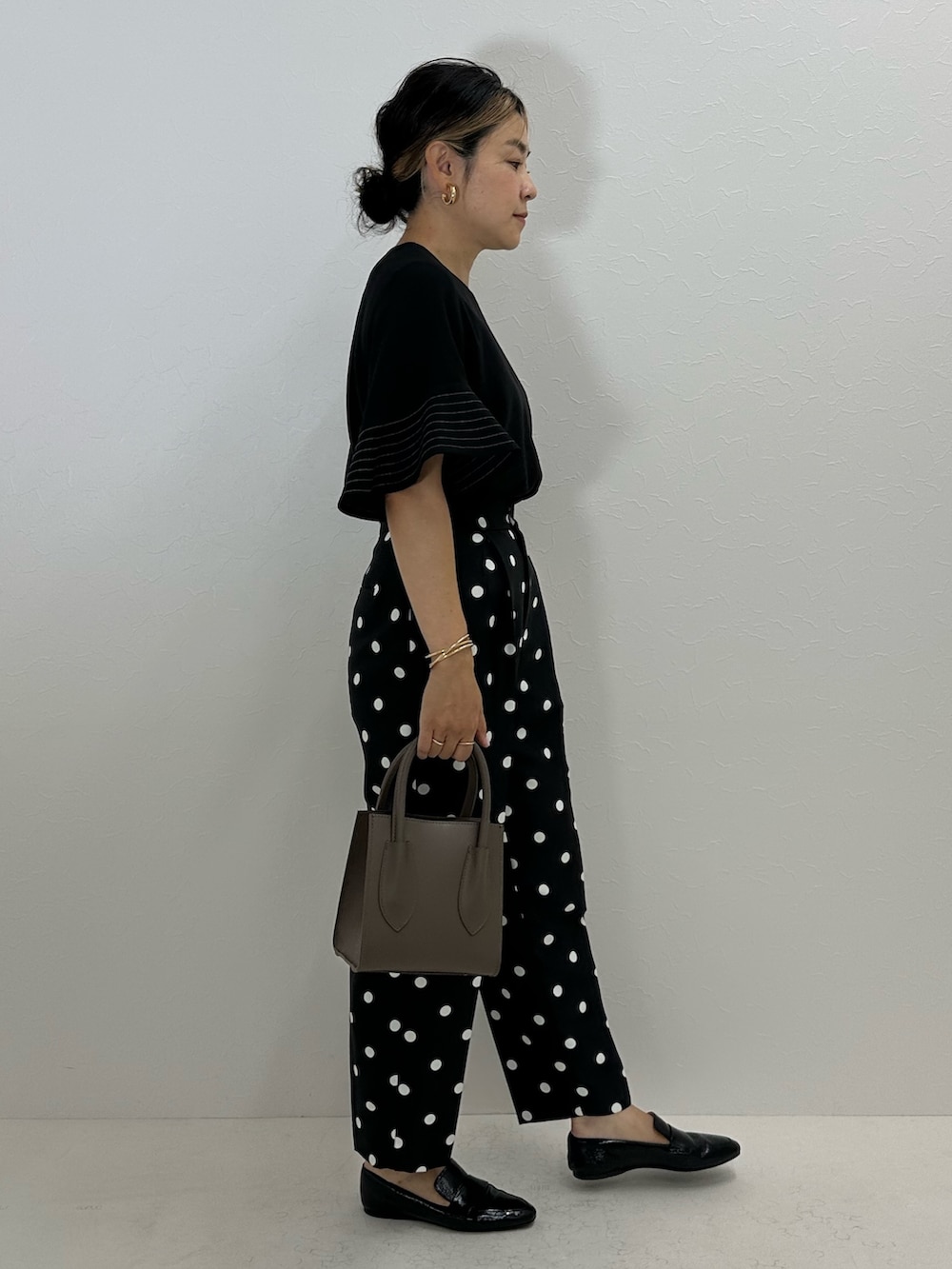 ブラック系のシャツ/ブラウス、ブラック系のその他パンツ、ベージュ系のトートバッグを着用したレディースの夏コーディネートの4枚目の写真