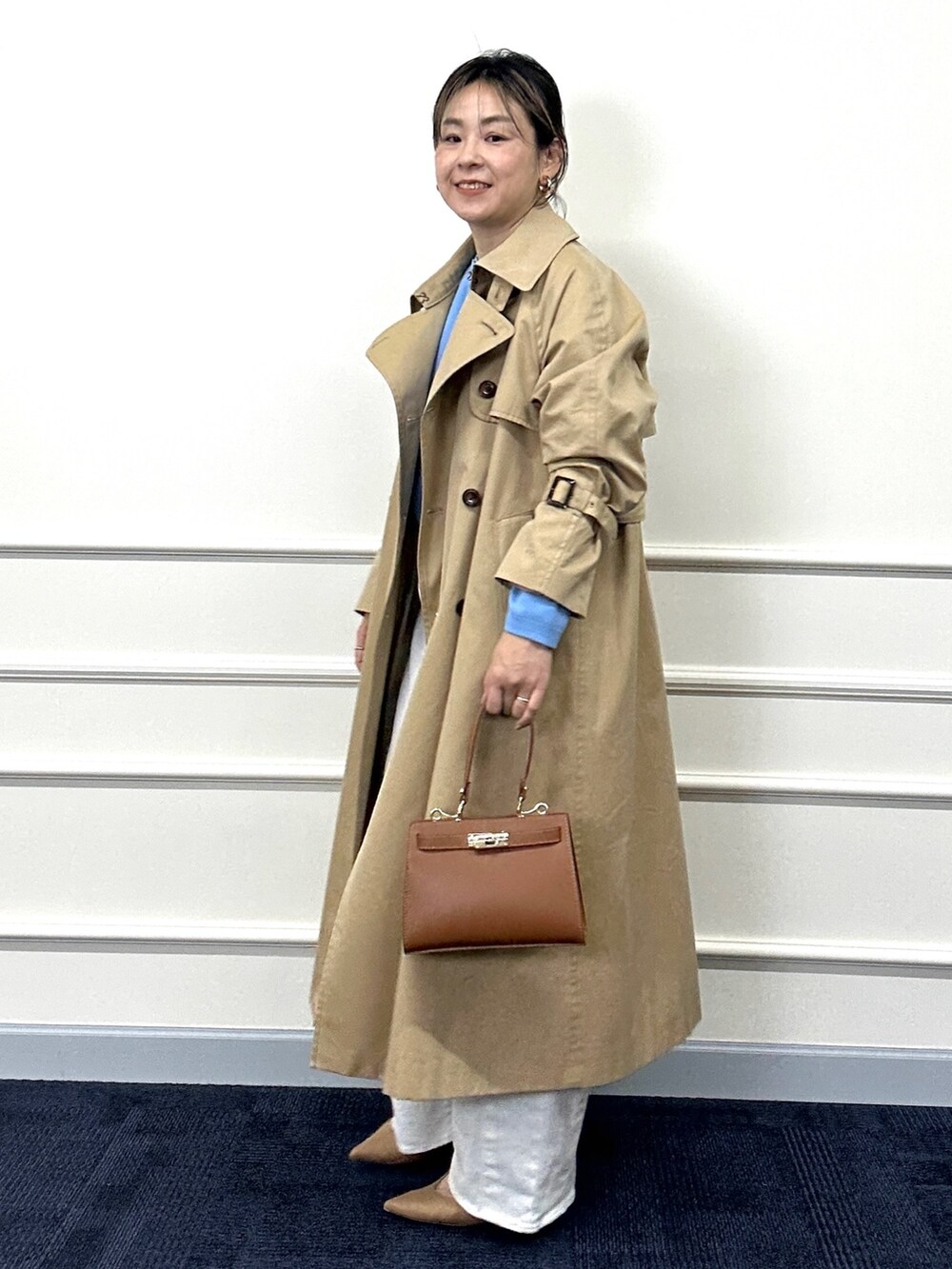 ベージュ系のトレンチコート、ブルー系のカーディガン/ボレロ、イエロー系のショルダーバッグを着用したレディースの春コーディネートの5枚目の写真
