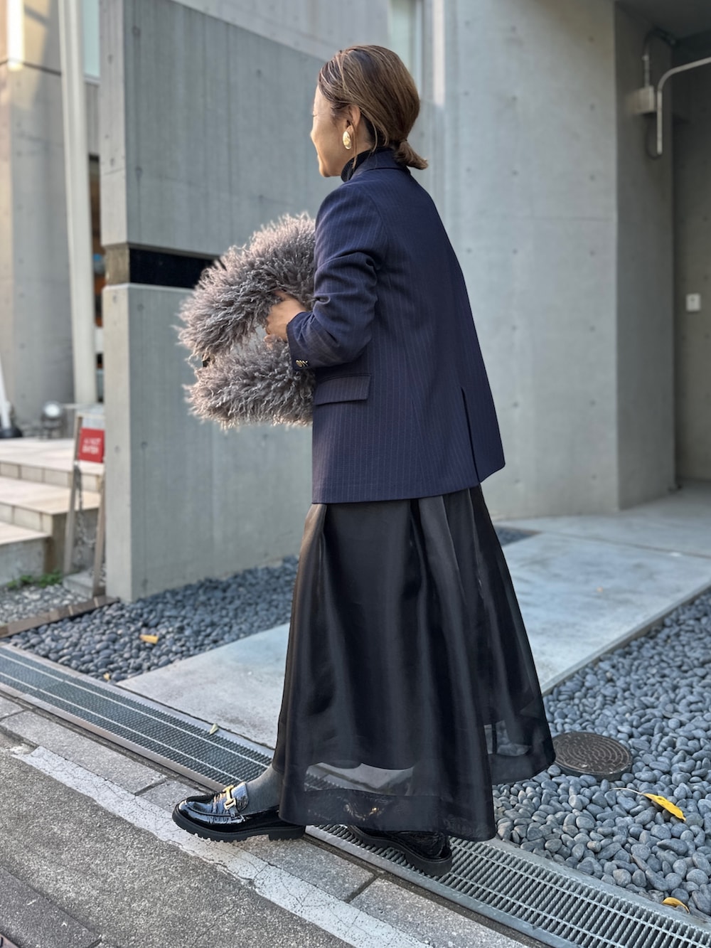 ブラック系のスカート、ブルー系のその他トップス、ブルー系のテーラードジャケットを着用したレディースの冬コーディネートの6枚目の写真