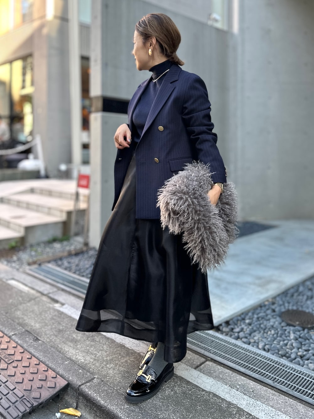 ブラック系のスカート、ブルー系のその他トップス、ブルー系のテーラードジャケットを着用したレディースの冬コーディネートの2枚目の写真