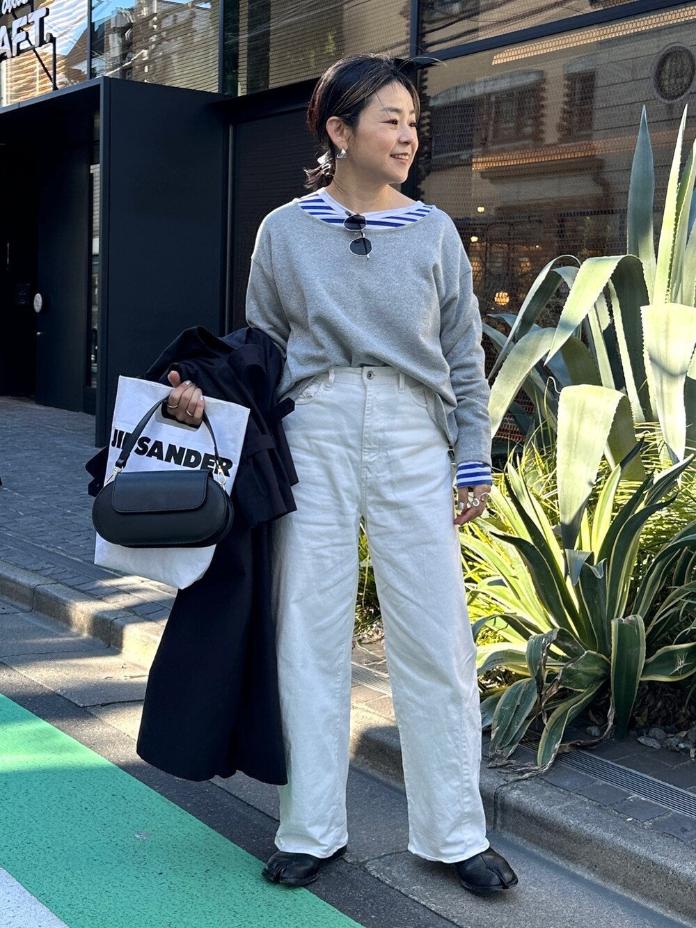 ブルー系のトレンチコート、ブルー系のTシャツ/カットソー、グレー系のTシャツ/カットソーを着用したレディースの春コーディネートの9枚目の写真