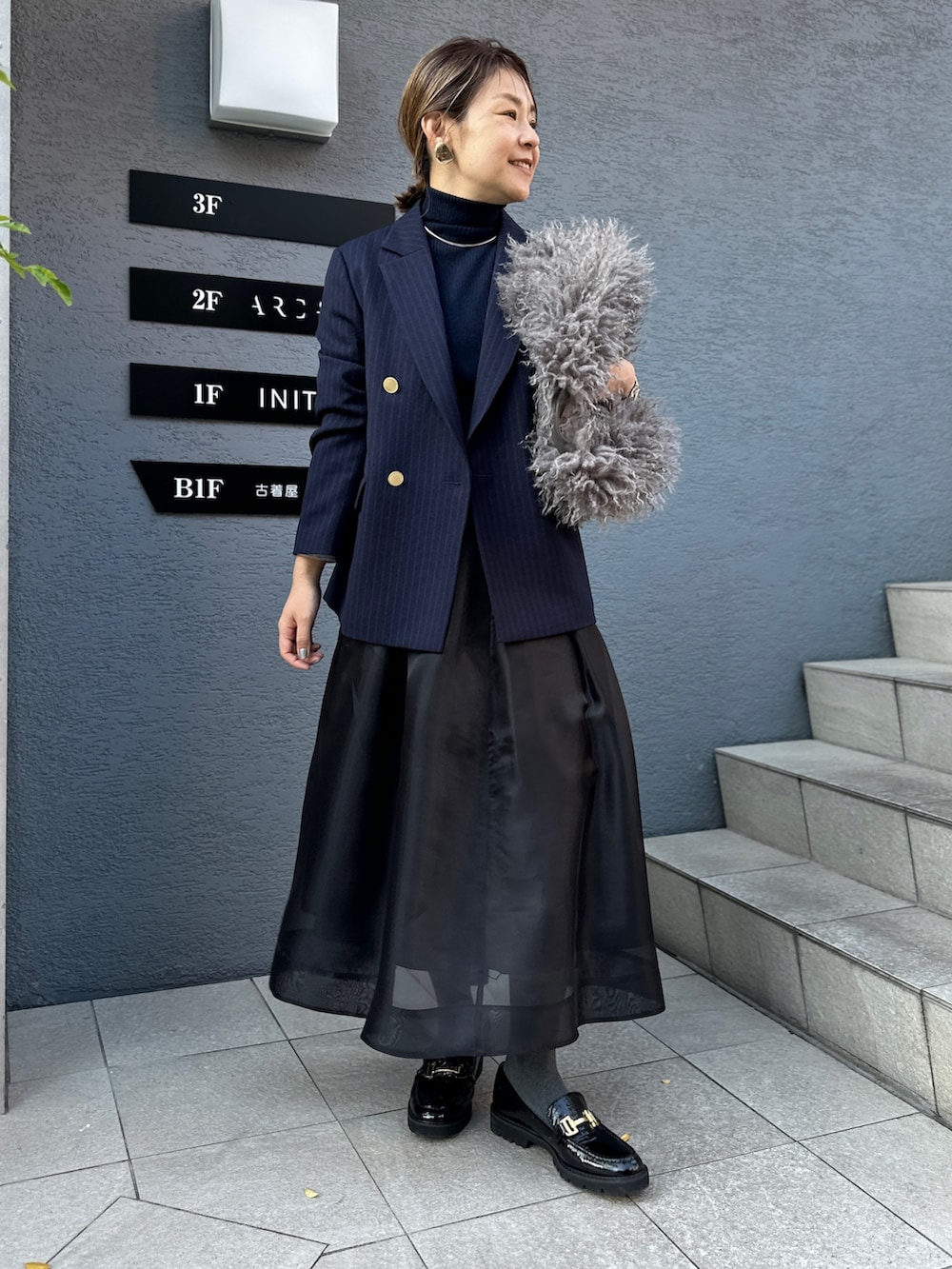 ブラック系のスカート、ブルー系のその他トップス、ブルー系のテーラードジャケットを着用したレディースの冬コーディネートの8枚目の写真