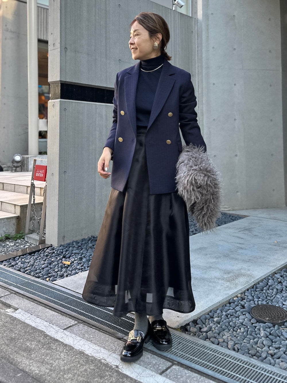 ブラック系のスカート、ブルー系のその他トップス、ブルー系のテーラードジャケットを着用したレディースの冬コーディネートの4枚目の写真