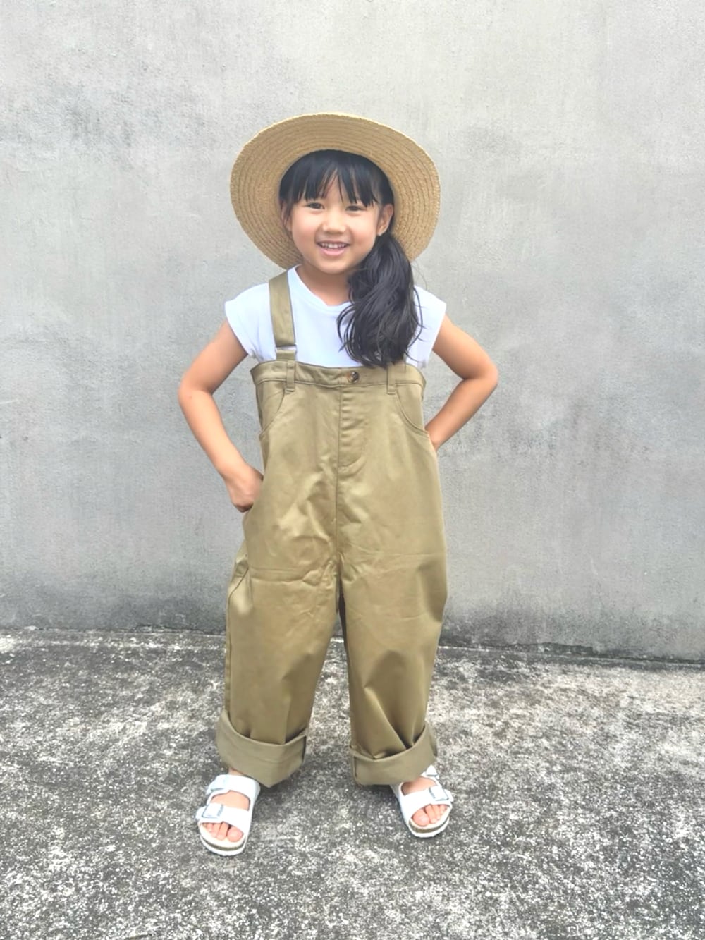 ベージュ系のサロペット/オーバーオール、ホワイト系のサンダル、ベージュ系のハットを着用したキッズの夏コーディネートの5枚目の写真